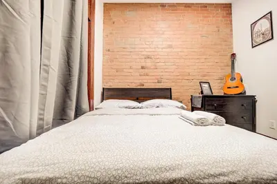 a bedroom with a bed next to a brick wall at Great 3B unit on Saint-Urbain in Montréal