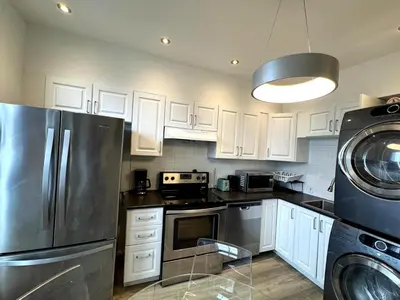 a kitchen with white cabinets and a stainless steel refrigerator at Hochelaga 1 in Montréal