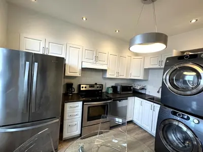 a kitchen with white cabinets and a stainless steel refrigerator at Hochelaga 1 in Montréal
