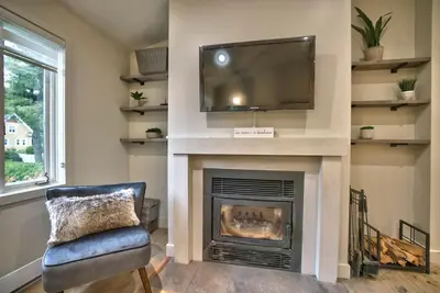 a living room with a fireplace with a flat screen tv at Le Southière, minimum 30 nuits in Magog-Orford