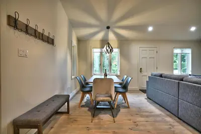 a dining room with a table and chairs and a couch at Le Southière, minimum 30 nuits in Magog-Orford