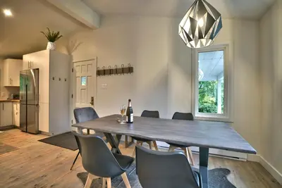 a dining room with a wooden table and chairs at Le Southière, minimum 30 nuits in Magog-Orford