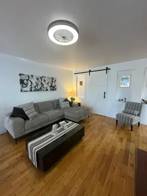 a living room with a couch and a table at Pointe Calumet, 30 minutes de Montréal max 8 pers in Pointe-Calumet
