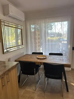a kitchen with a wooden table and chairs and a window at Pointe Calumet, 30 minutes de Montréal max 8 pers in Pointe-Calumet