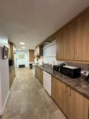 a large kitchen with wooden cabinets and a counter top at Pointe Calumet, 30 minutes de Montréal max 8 pers in Pointe-Calumet