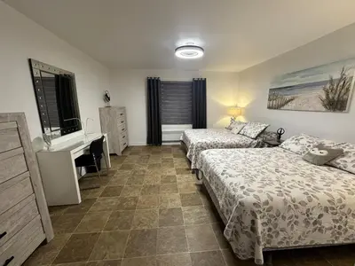 a bedroom with two beds and a desk and a sink at Pointe Calumet, 30 minutes de Montréal max 8 pers in Pointe-Calumet