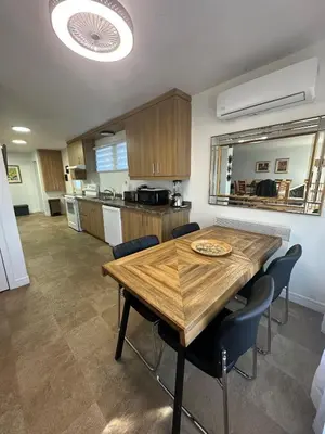 a kitchen and dining room with a wooden table and chairs at Pointe Calumet, 30 minutes de Montréal max 8 pers in Pointe-Calumet