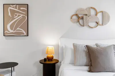 a white bedroom with a white couch and a lamp at Boho Luxe 2-Floor Retreat Sleeps 6 Private Patio in Montréal