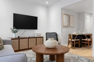 a living room with a tv and a table at Boho Luxe 2-Floor Retreat Sleeps 6 Private Patio in Montréal