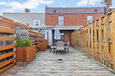a patio with a table and chairs on a wooden walkway at Boho Luxe 2-Floor Retreat Sleeps 6 Private Patio in Montréal