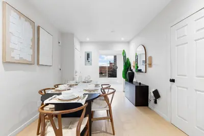 a white dining room with a table and chairs at Boho Luxe 2-Floor Retreat Sleeps 6 Private Patio in Montréal