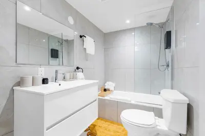 a white bathroom with a toilet and a sink at Boho Luxe 2-Floor Retreat Sleeps 6 Private Patio in Montréal