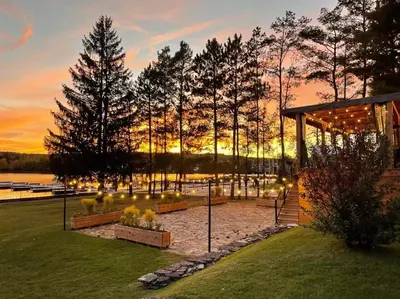 a pavilion with trees and a sunset in the background at Auberge l'Intermède du lac in Disraeli