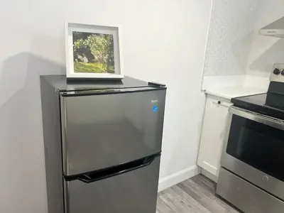 a refrigerator in a kitchen with a picture on top of it at 10 minutes to Montreal entire place 2 bedrooms private entrance in Laprairie