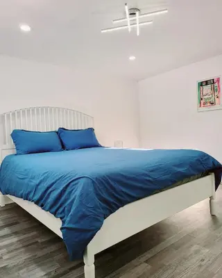 a bedroom with a bed with blue pillows at 10 minutes to Montreal entire place 2 bedrooms private entrance in Laprairie