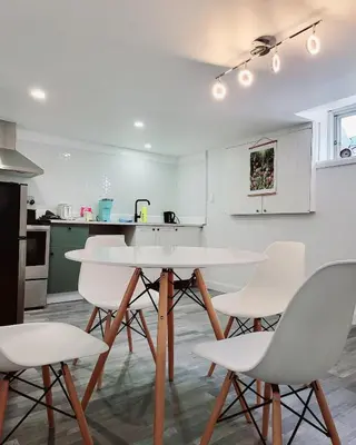 a kitchen with a white table and white chairs at 10 minutes to Montreal entire place 2 bedrooms private entrance in Laprairie