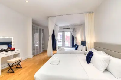 a white bedroom with a large bed and a couch at Take a break in a modern loft on the plateau Walk score 99 in Montréal