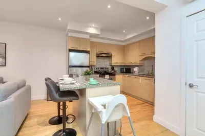 a kitchen and living room with a table and chairs at Take a break in a modern loft on the plateau Walk score 99 in Montréal