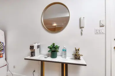 a mirror on a wall next to a shelf with a plant at Take a break in a modern loft on the plateau Walk score 99 in Montréal