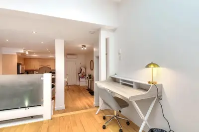 a home office with a desk and a television at Take a break in a modern loft on the plateau Walk score 99 in Montréal
