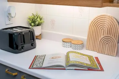 a kitchen counter with a book and a toaster at Cozy Montreal Entire Apartment-3min walk to Metro-free parking-Botanical garden-biodome in Montréal