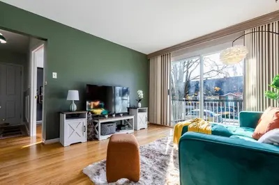 a living room with a blue couch and a tv at Cozy Montreal Entire Apartment-3min walk to Metro-free parking-Botanical garden-biodome in Montréal