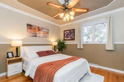 a bedroom with a bed and a ceiling fan at Cozy Montreal Entire Apartment-3min walk to Metro-free parking-Botanical garden-biodome in Montréal