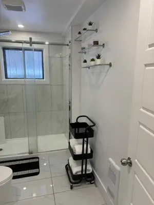 a bathroom with a shower and a black towel rack at Rima in Montréal