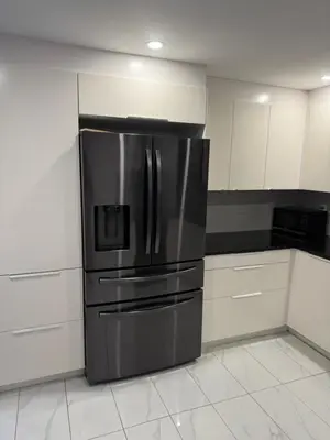 a stainless steel refrigerator in a kitchen with white cabinets at Rima in Montréal