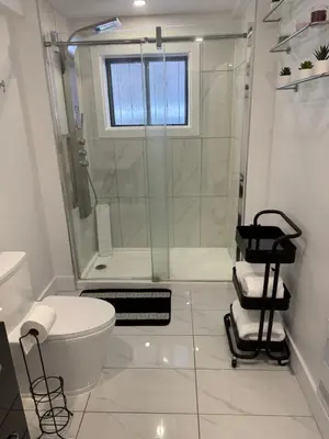 a white bathroom with a shower and a toilet at Rima in Montréal