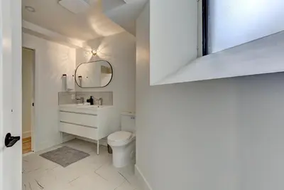 a white bathroom with a toilet and a mirror at Les Lofts du Mile End-Plateau Mont Royal in Montréal