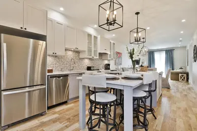 a kitchen with white cabinets and a kitchen island with bar stools at Les Lofts du Mile End-Plateau Mont Royal in Montréal