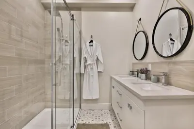 a bathroom with a shower and two sinks and a mirror at Les Lofts du Mile End-Plateau Mont Royal in Montréal