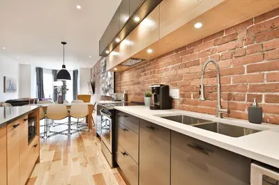 a kitchen with a brick wall and a sink at Les Lofts du Mile End-Plateau Mont Royal in Montréal