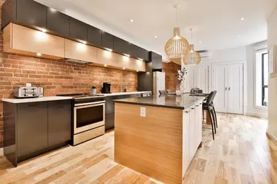 a kitchen with a counter and a brick wall at Les Lofts du Mile End-Plateau Mont Royal in Montréal