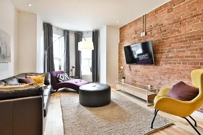 a living room with a couch and a brick wall at Les Lofts du Mile End-Plateau Mont Royal in Montréal