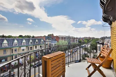 a balcony with a chair and a view of a city at Les Lofts du Mile End-Plateau Mont Royal in Montréal