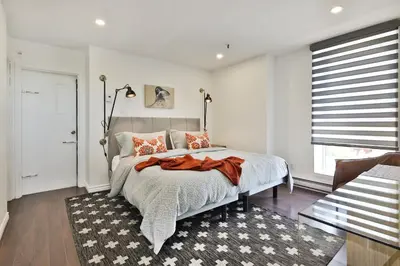 a bedroom with a bed with an orange blanket on it at Mont Royal Prime Residence in Montréal