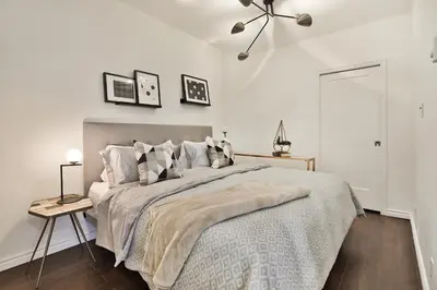 a white bedroom with a large bed and a table at Mont Royal Prime Residence in Montréal