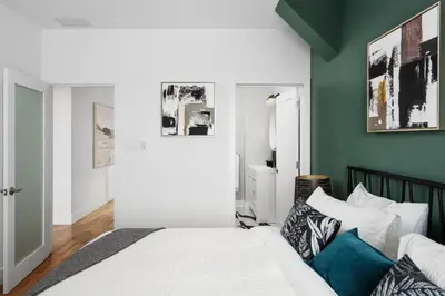 a bedroom with a white bed and a green wall at Mont Royal Prime Residence in Montréal
