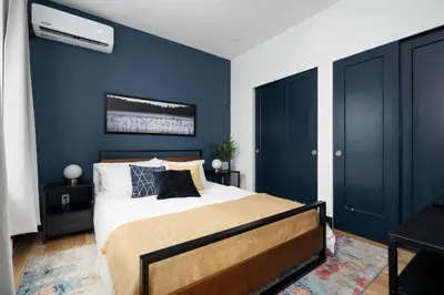 a bedroom with a large bed with blue walls at Les Residences Saint Laurent- Parc Mont Royal in Montréal