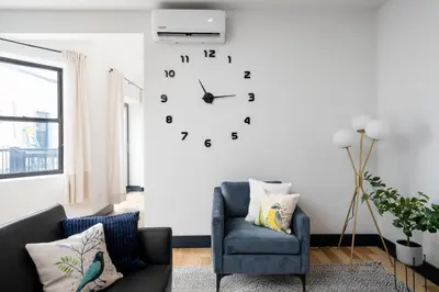a living room with a clock on the wall at Les Residences Saint Laurent- Parc Mont Royal in Montréal