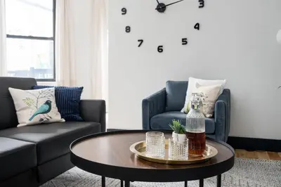 a living room with a coffee table and a clock on the wall at Les Residences Saint Laurent- Parc Mont Royal in Montréal