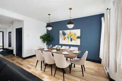 a dining room with a blue wall and a table and chairs at Les Residences Saint Laurent- Parc Mont Royal in Montréal