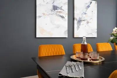 a dining room with a black table and orange chairs at Les Residences Saint Laurent- Parc Mont Royal in Montréal