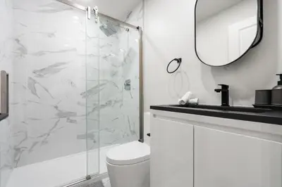 a bathroom with a shower and a toilet and a sink at The Griffin ApartHotel- Downtown in Montréal