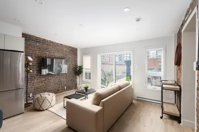 a living room with a couch and a brick wall at The Griffin ApartHotel- Downtown in Montréal