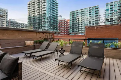 a rooftop deck with chairs and buildings at The Griffin ApartHotel- Downtown in Montréal