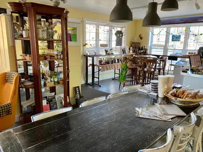 a room with a table and chairs in a store at Auberge Le Sunshine in Stanstead Plain