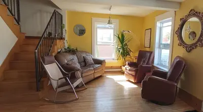 a living room with a couch and two chairs at Auberge Le Sunshine in Stanstead Plain